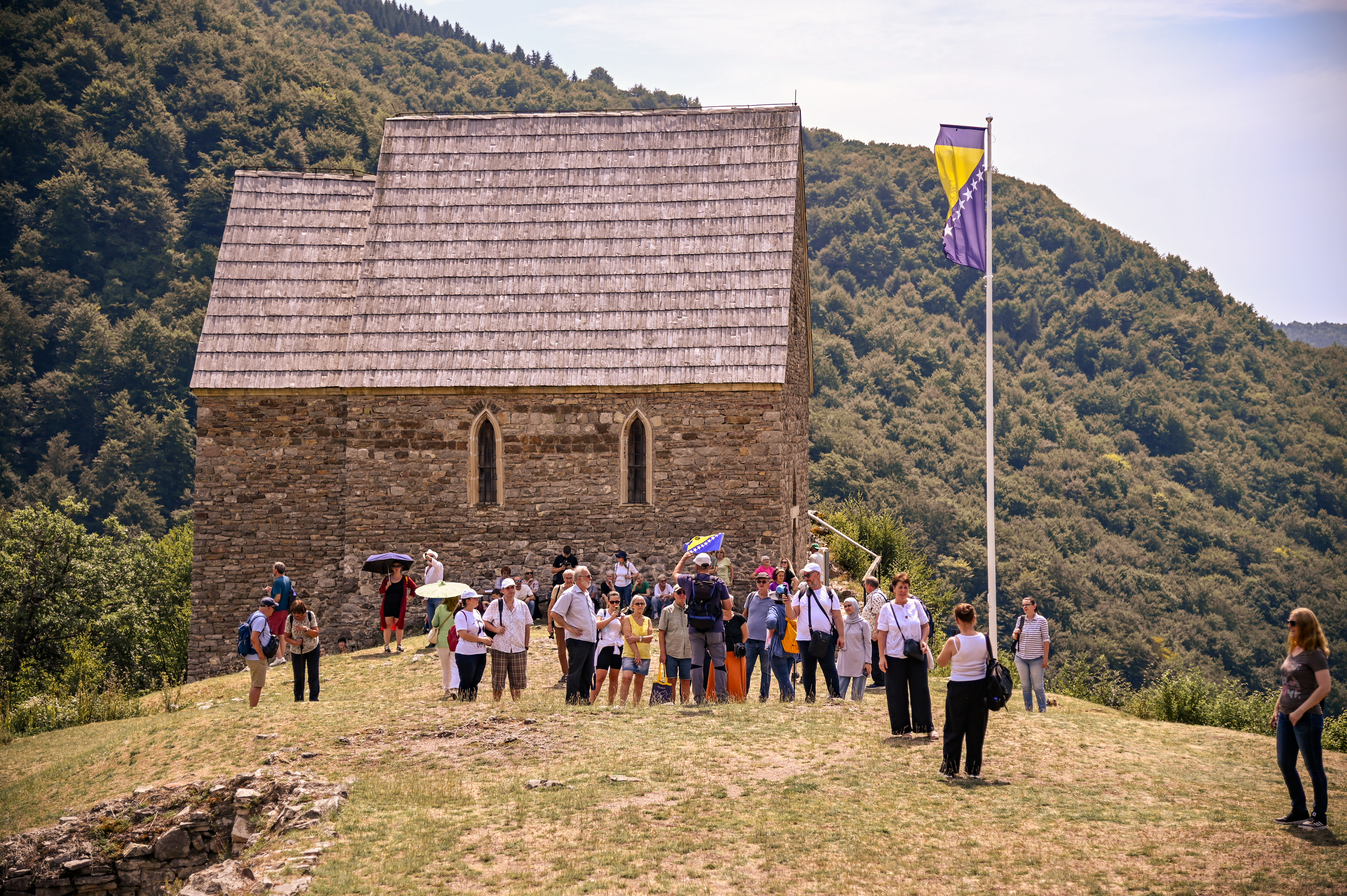 Travelers in Bosnia and Herzegovina with a historic Bosnian setting behind them